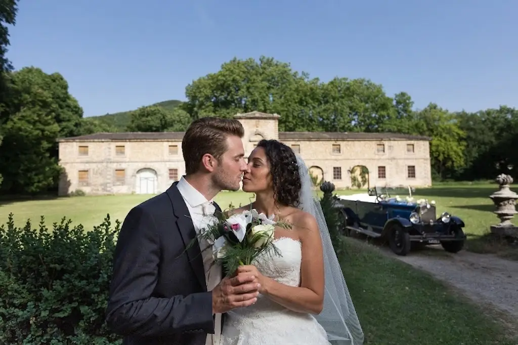 Couple de mariés devant un gîte de groupe avec parc