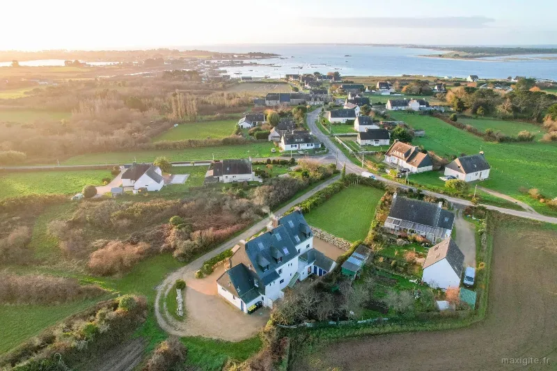 Vue aerienne du domaine au coucher de soleil avec jardin, hameau et mer au loin