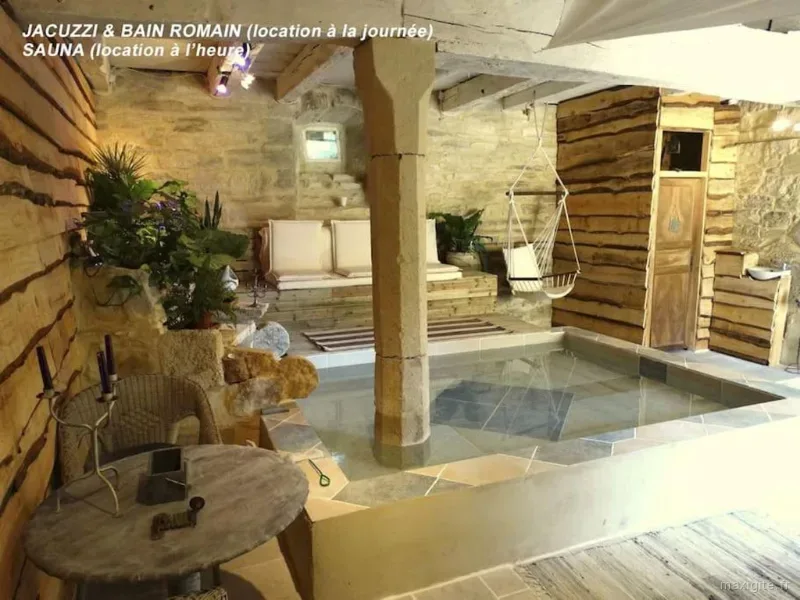 Jacuzzi bain romain en pierre avec banquette, fauteuil suspendu et ambiance chaleureuse boisée