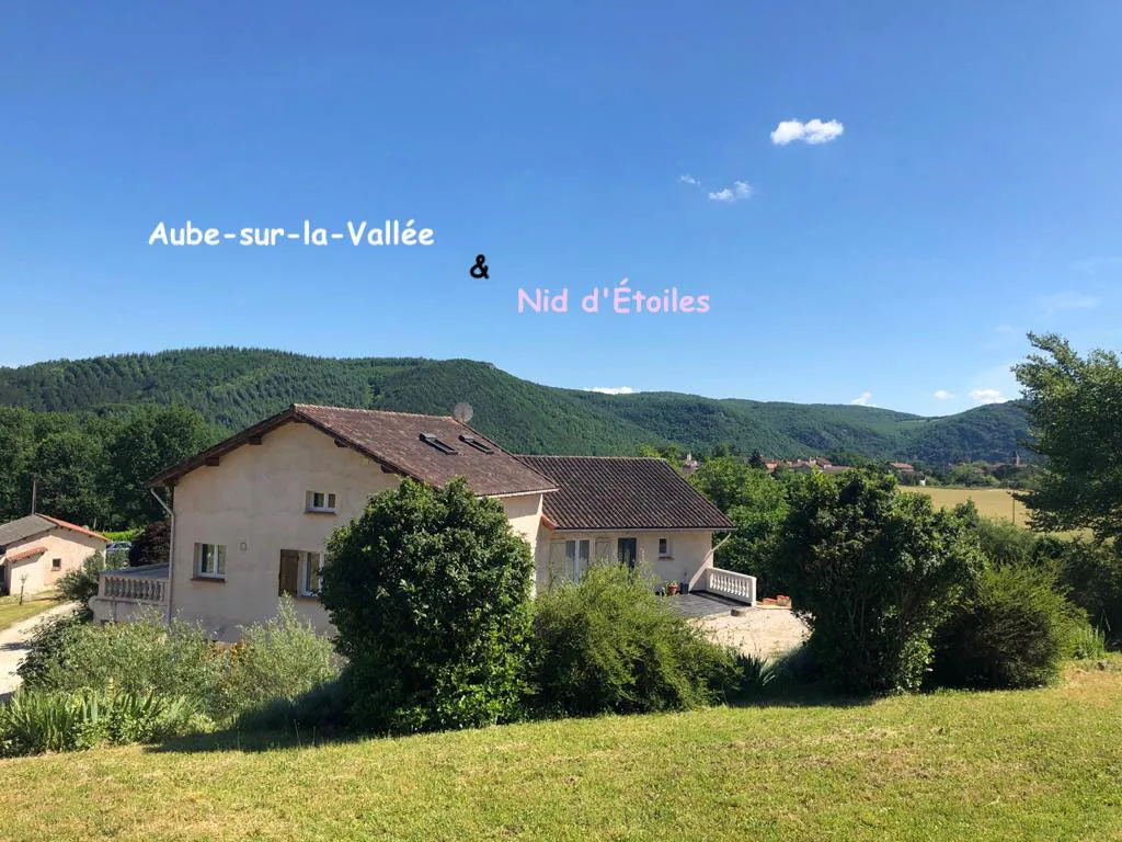 Gîte de groupe Les Figuiers de Louna à Saint-Géry — Façade de la maison en pleine campagne avec terrasse et vue sur les collines boisées verdoyantes, capacité 30 personnes