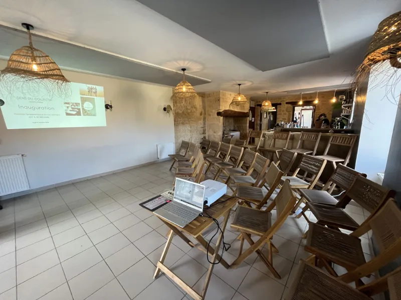 Salle de réception agencée en rangées de chaises face à un écran de projection pour événements