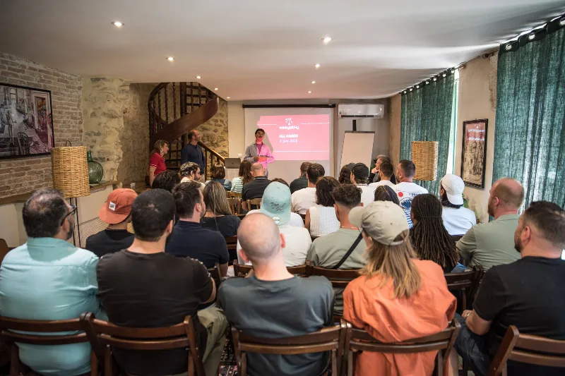 Salle intérieure accueillant un groupe assis face à un écran lors d'une présentation conviviale