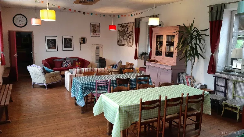 Salle commune colorée avec tables à carreaux, buffet rose et canapés rayés
