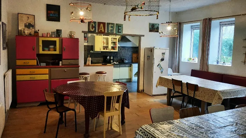 Cuisine rétro avec meubles vintage rouges, enseigne CAFÉ et tables conviviales