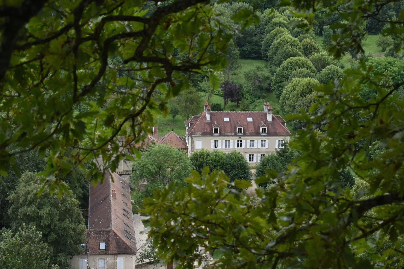 Gîte de groupe Domaine des Douves à Ancy-le-Franc — Vue aérienne du Domaine des Douves, bâtisses en pierre de Bourgogne entourées d’un parc boisé de 10 hectares, capacité 45 personnes