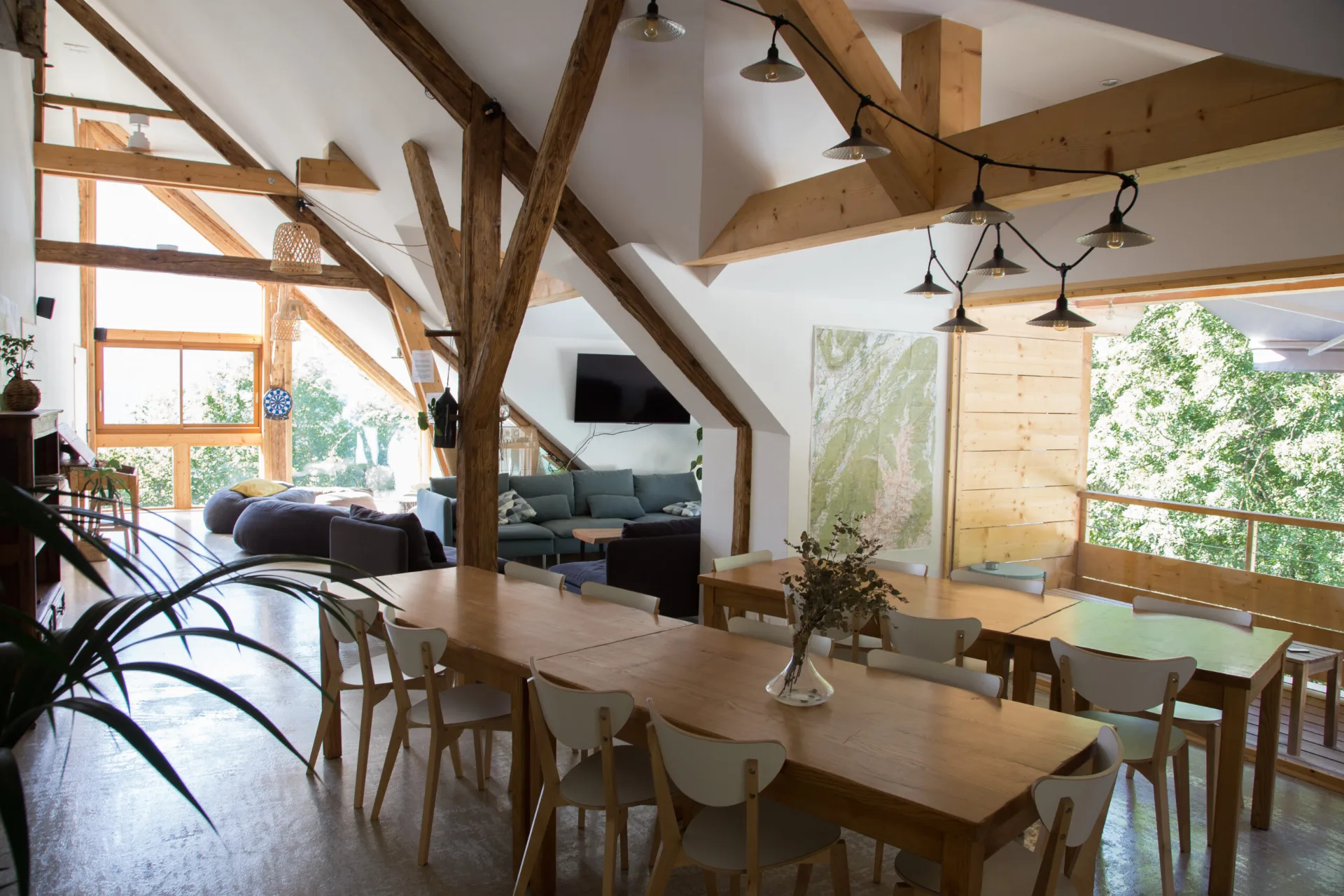 Gîte de groupe Ferme Croq'Champs – Grand Gîte Écologique à Saint-Alban-des-Hurtières — Grande salle à manger avec charpente en bois et tables en bois clair, capacité 17 personnes