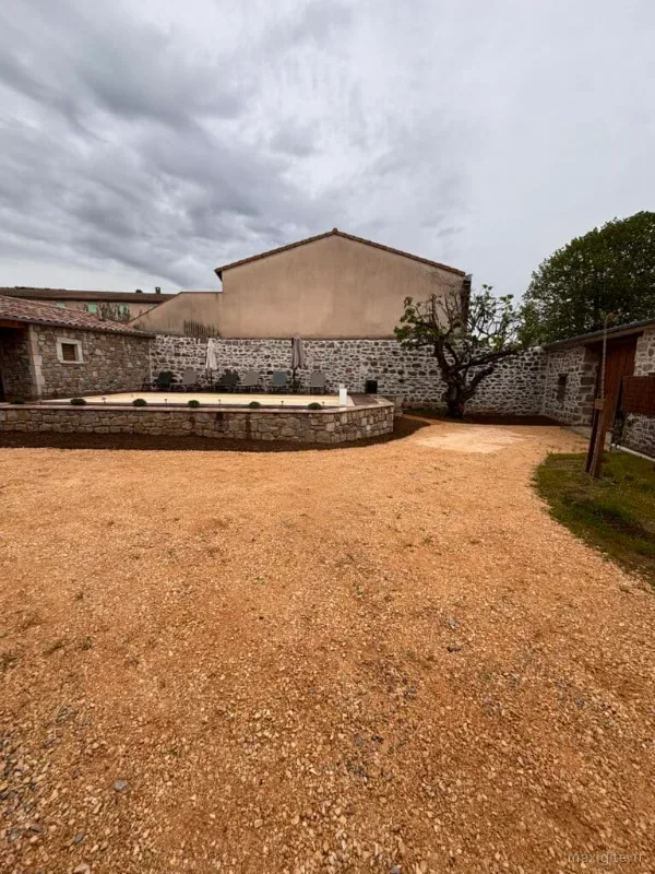 Vue d'ensemble de la cour intérieure de La Maison des Papés à Laurac-en-Vivarais, piscine et bâtisse en pierre