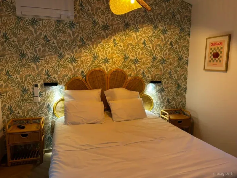 Suite double avec lit double, tête de lit en rotin et papier peint tropical aux motifs de feuilles exotiques