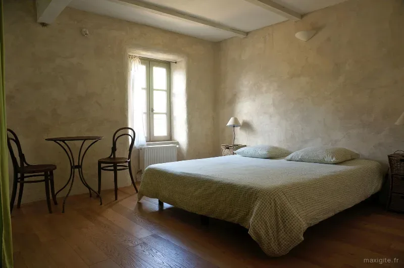 Chambre double avec lit queen size, parquet bois clair et enduit naturel aux tons beiges