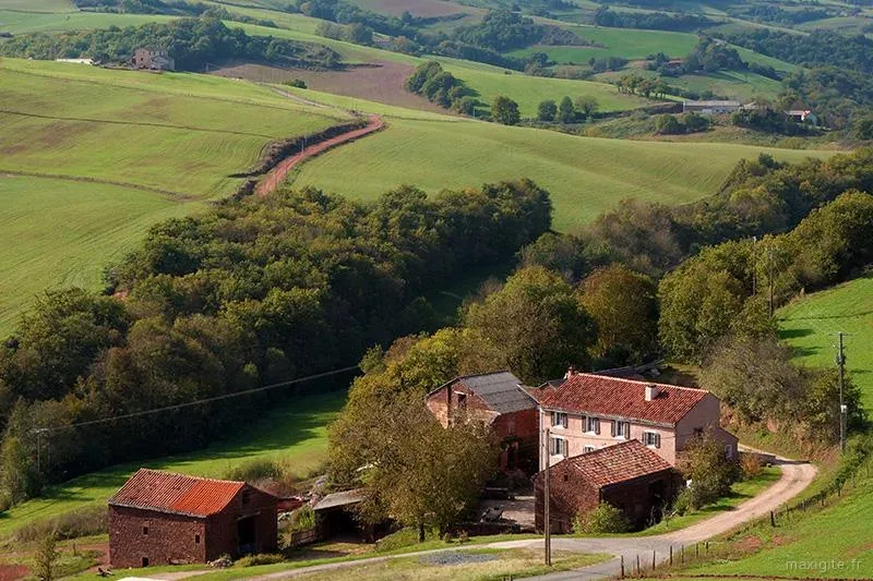 Gîte de groupe Les Gîtes du Brugas à Saint-Juéry — Vue d'ensemble du hameau en grès rouge niché dans les collines verdoyantes de l'Aveyron, capacité 23 personnes