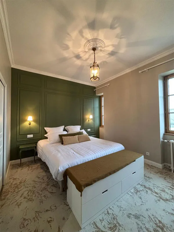 Chambre vert sapin avec tête de lit boiseries moulurées et lanterne dorée
