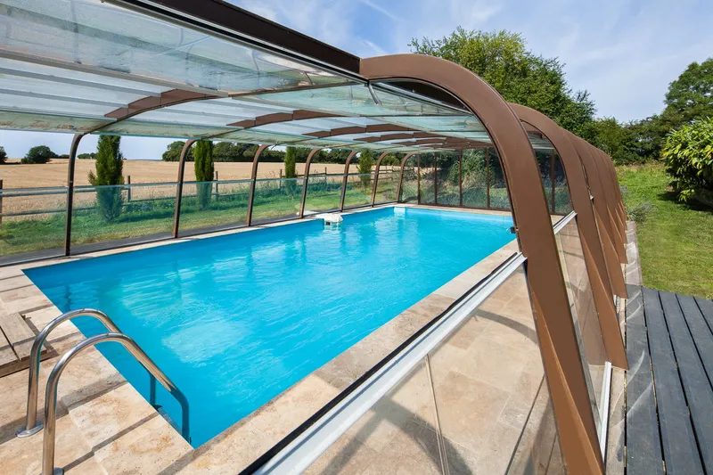 Piscine privée du Domaine de la Cour entourée d'un espace vert préservé en Normandie