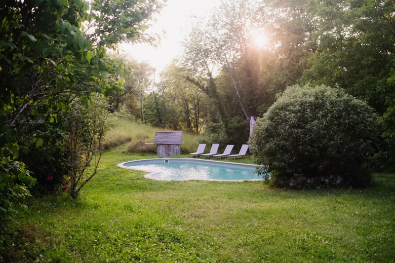 Jardin à la française du Domaine de Cugnac avec fontaine et vue sur les prairies du Périgord