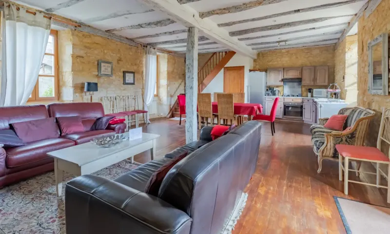 Intérieur chaleureux du gîte avec pierres apparentes et poutres