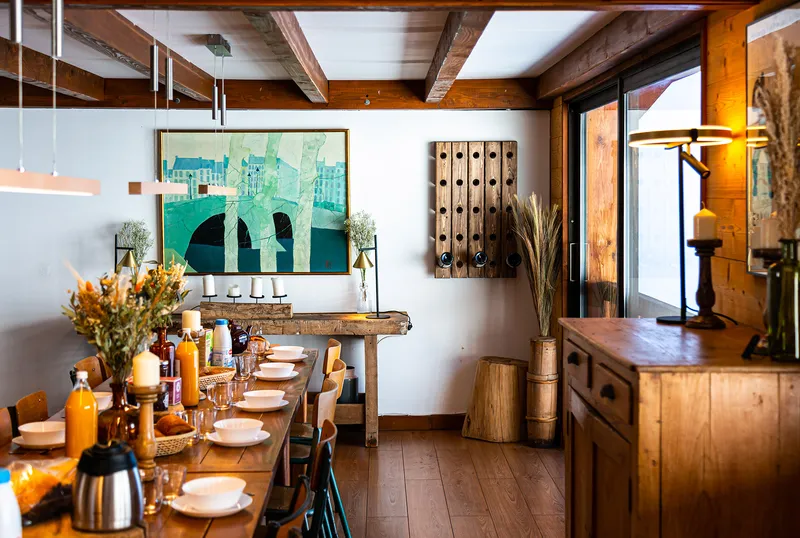 Table de brunch dressée dans le séjour du chalet face aux Aravis enneigés