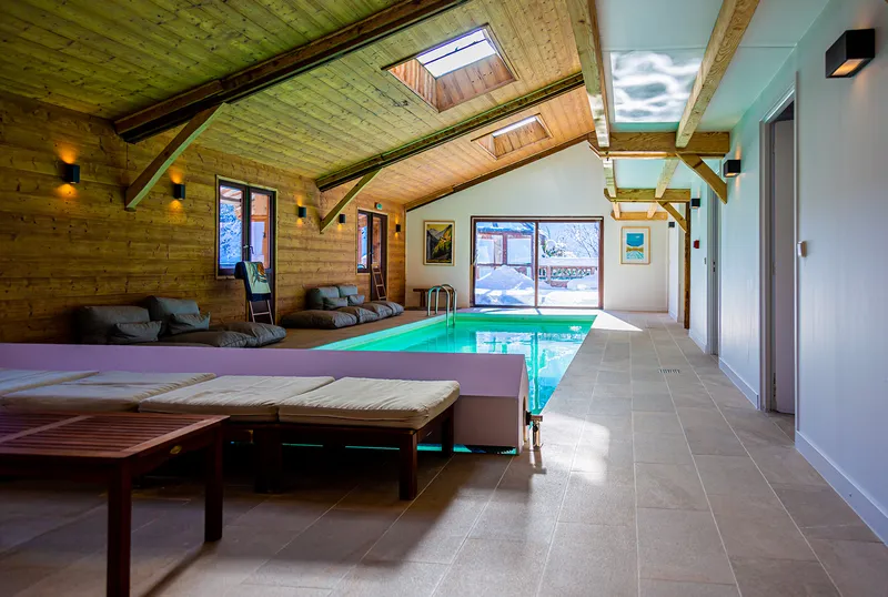 Piscine intérieure chauffée du chalet avec vue sur les sommets enneigés des Aravis