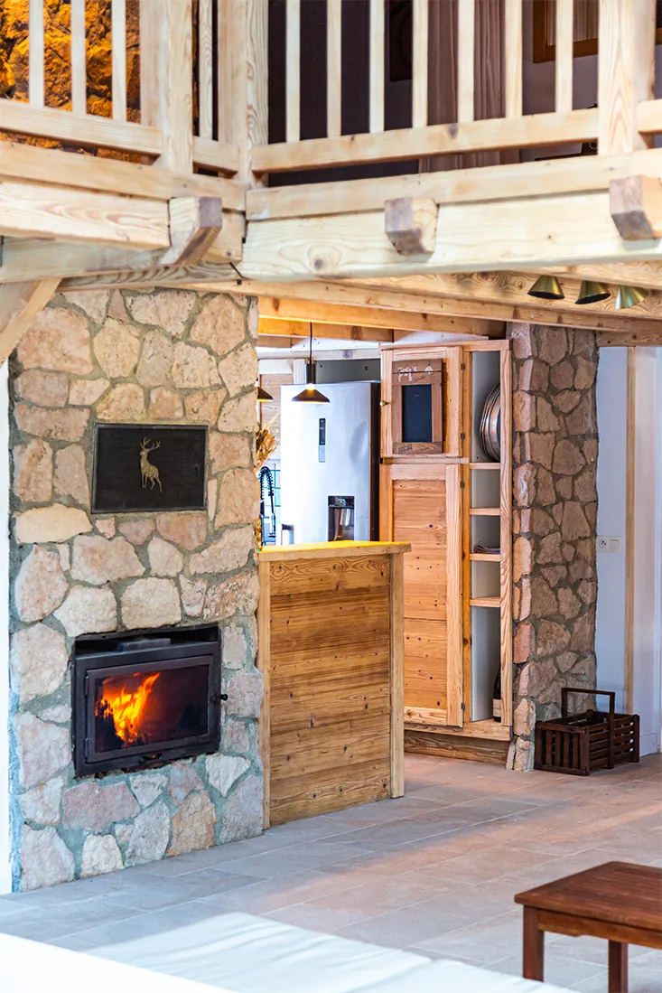 Cuisine équipée du chalet avec îlot et ouverture sur le salon et la montagne
