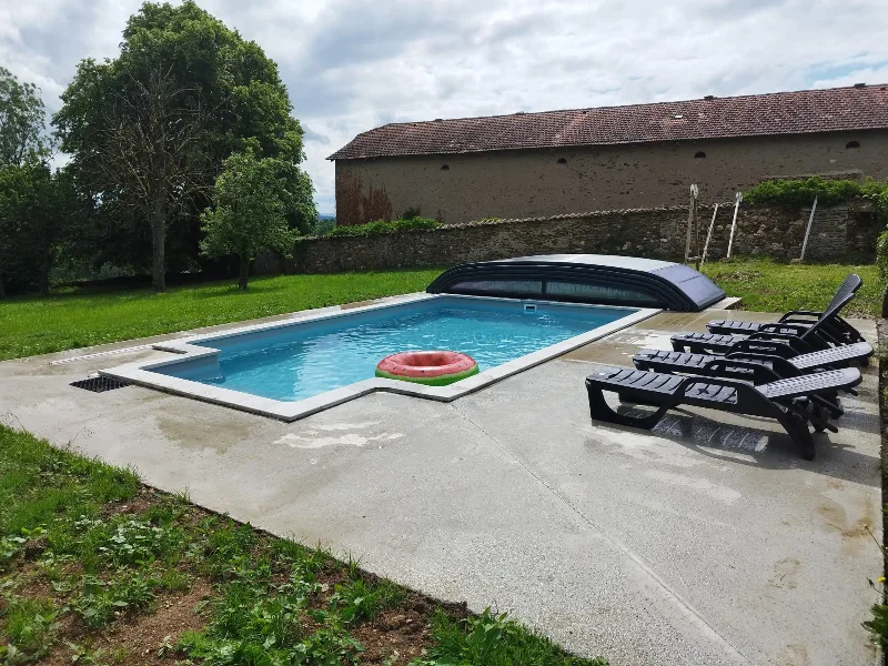 Piscine chauffable avec transats, entourée de prairies et d'arbres centenaires