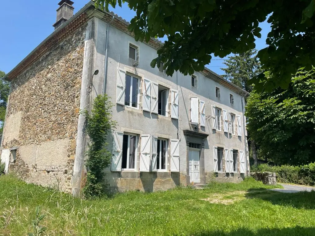 Gîte de groupe Château de Cologne à Naucelles — Façade en pierre du Château de Cologne à Naucelles, bâtisse du XIIe siècle entourée de verdure, capacité 22 personnes