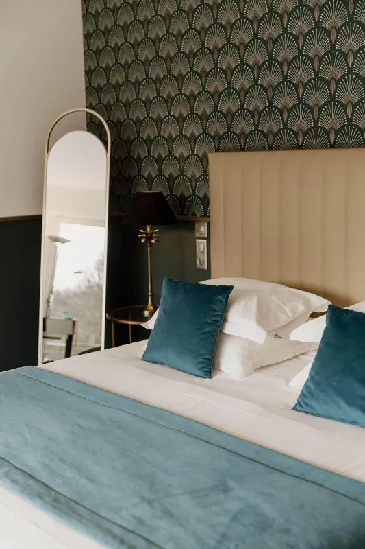 Chambre cosy avec tête de lit capitonnée et coussins bleu paon