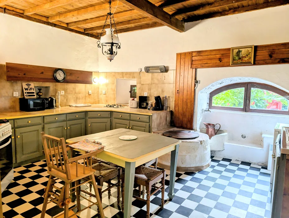 Salle à manger au sol en damier avec longue table en bois pour douze convives