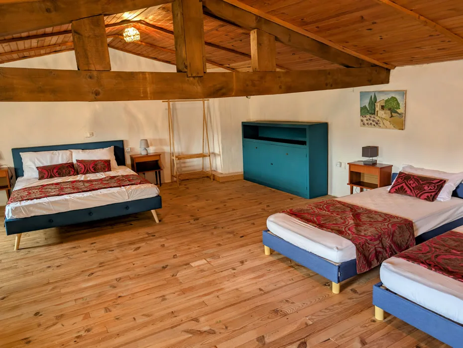 Chambre mansardée avec poutres apparentes et deux lits simples