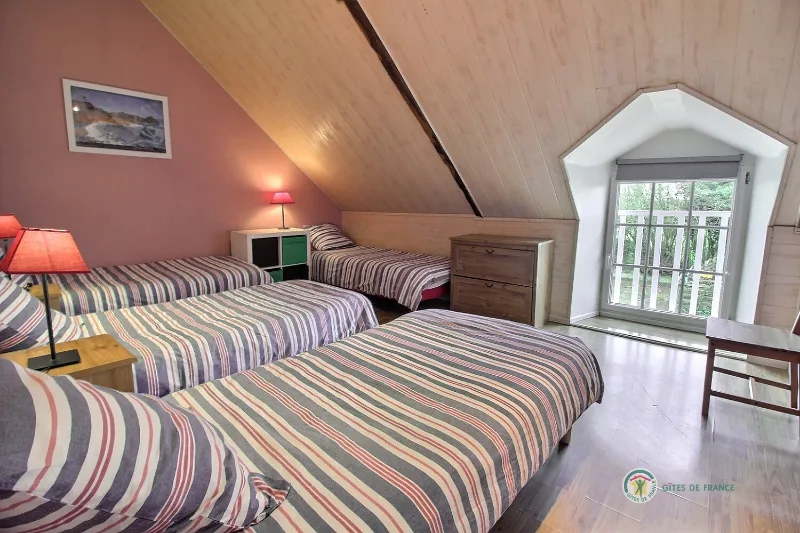 Chambre aux tons roses avec deux lits simples et parquet