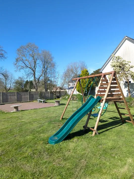 Jardin avec aire de jeux, balançoire et toboggan pour les enfants
