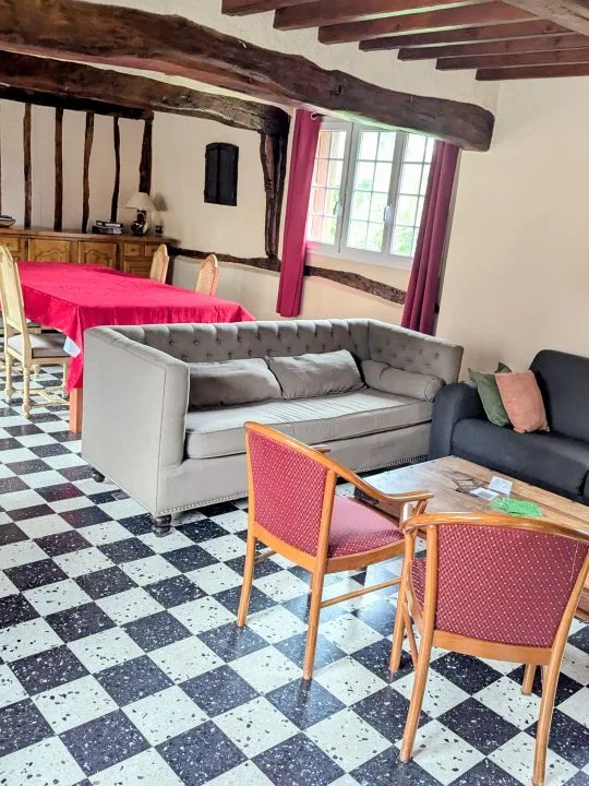 Salon confortable avec canapés et fauteuils sur sol en damier
