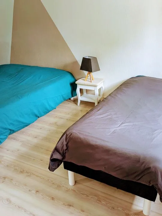 Chambre avec lit bleu et linge de lit chaleureux