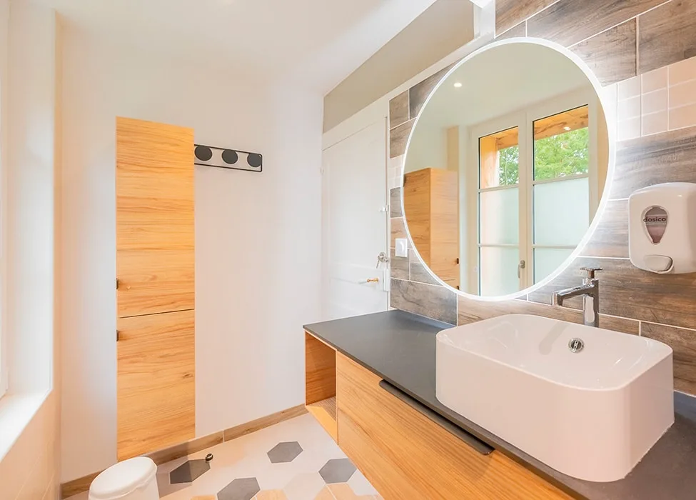 Salle de douche moderne avec miroir rond et double vasque en bois