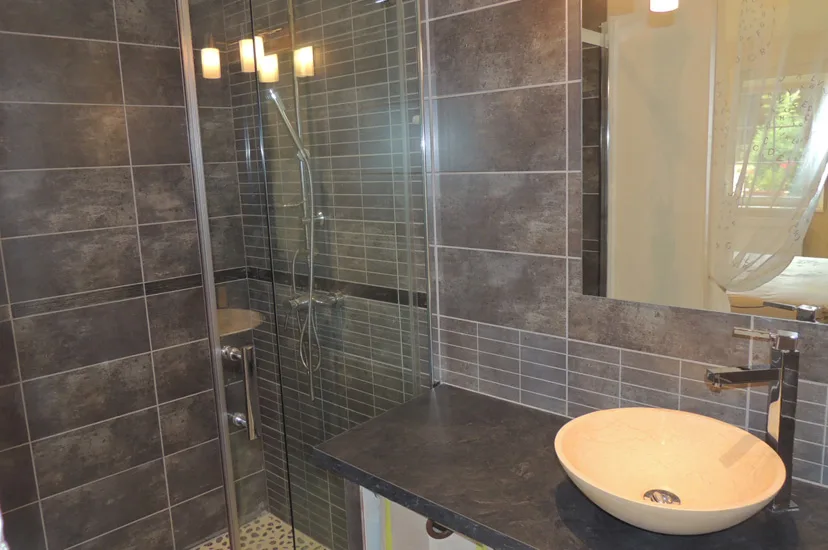 Salle de bain moderne avec vasque ronde et faïence sombre