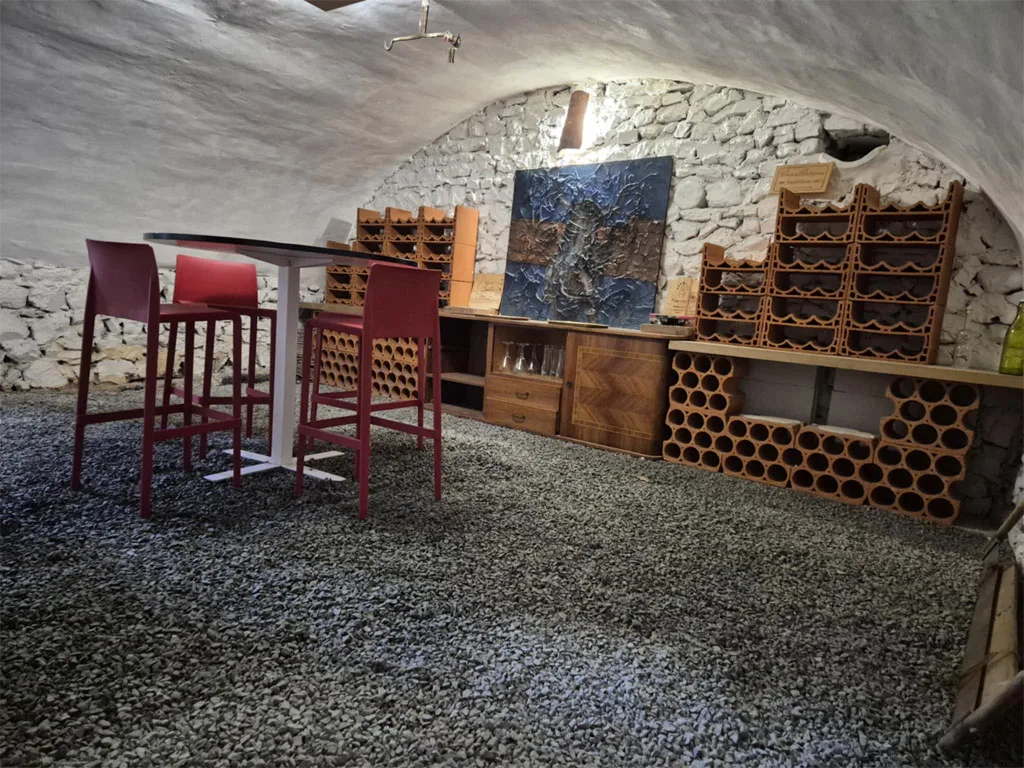 Ancien coin voûté en pierre aménagé en espace détente avec bar et rangements