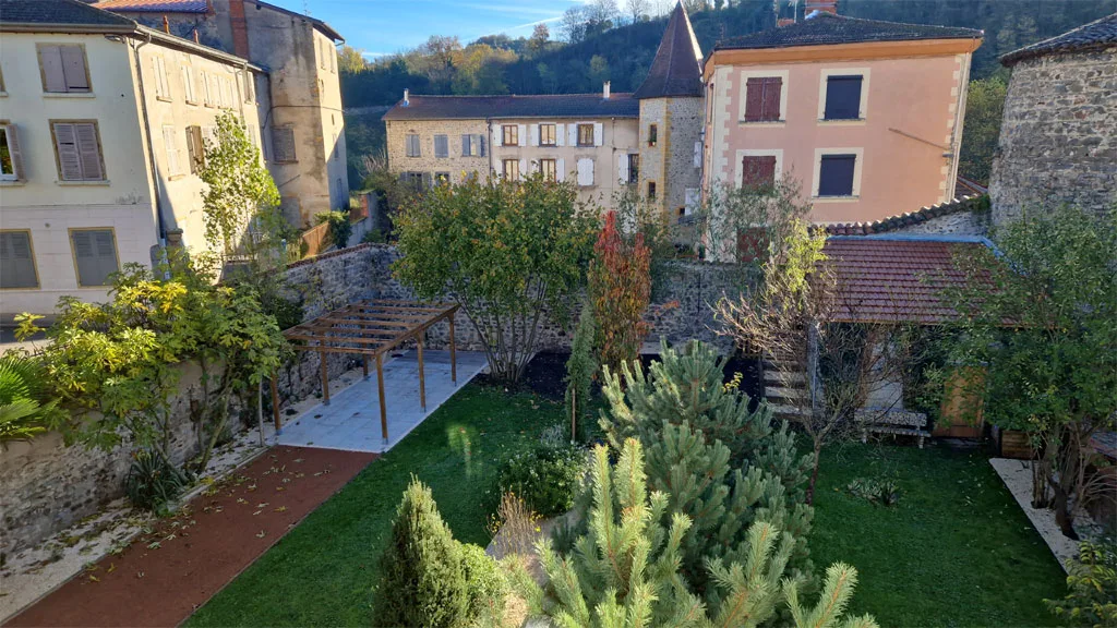 Vue sur le jardin en terrasses avec les remparts et toitures du village en arrière-plan