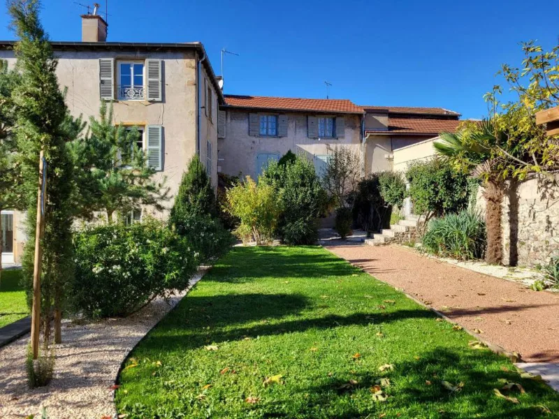 Cour intérieure pavée avec pelouse et bâtisse en pierre du village médiéval de Régny