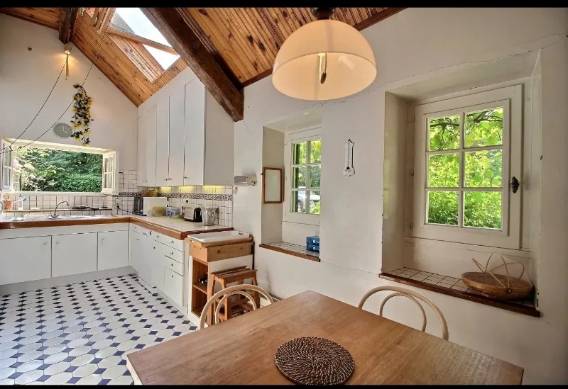 Cuisine campagnarde avec carrelage à damier, plan de travail en bois et coin repas
