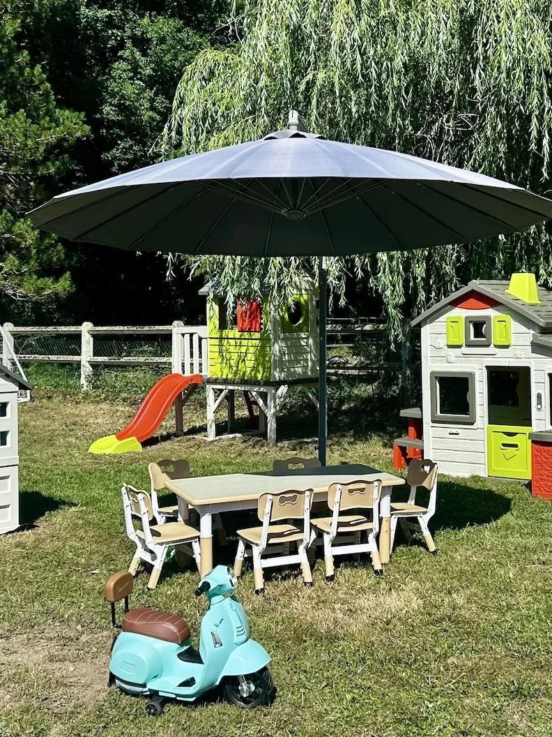 Coin de jeux pour enfants avec toboggan et mobilier coloré dans le jardin