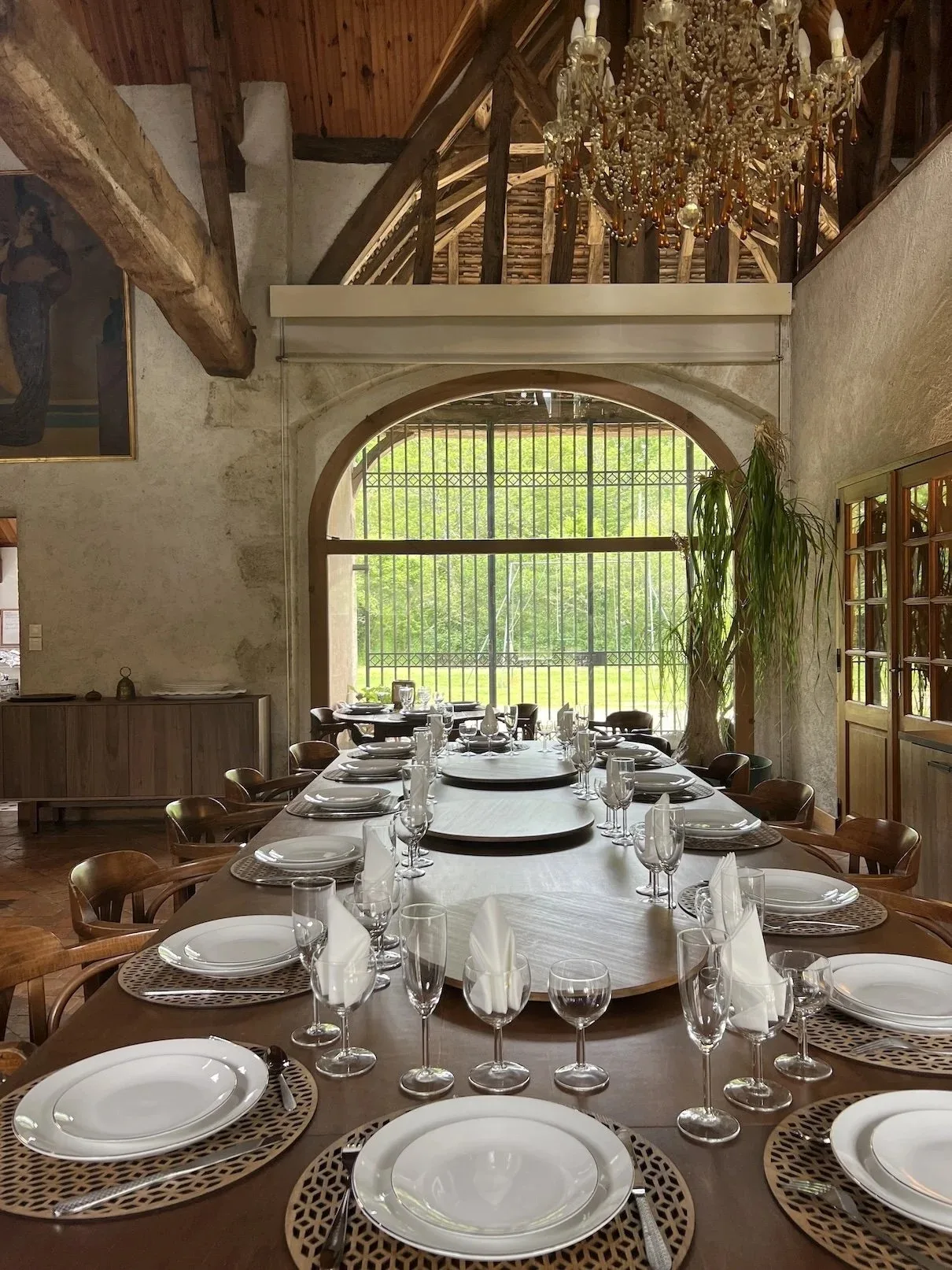 Salle à manger dressée avec grande table pour dix-neuf convives sous charpente en colombages