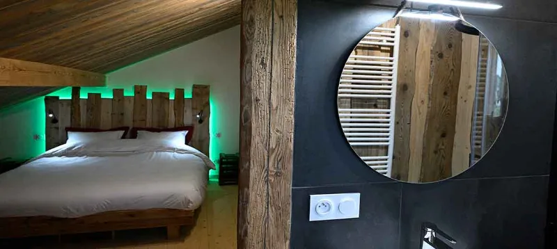 Chambre mezzanine avec lit double et salle de bain attenante en bois brut