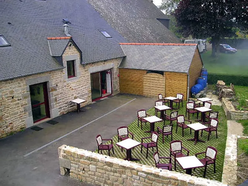 Terrasse extérieure aménagée avec tables et chaises pour les repas en plein air
