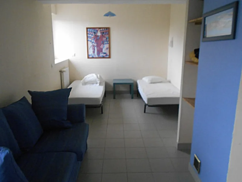 Chambre avec deux lits jumeaux et rangements pratiques pour un séjour de groupe