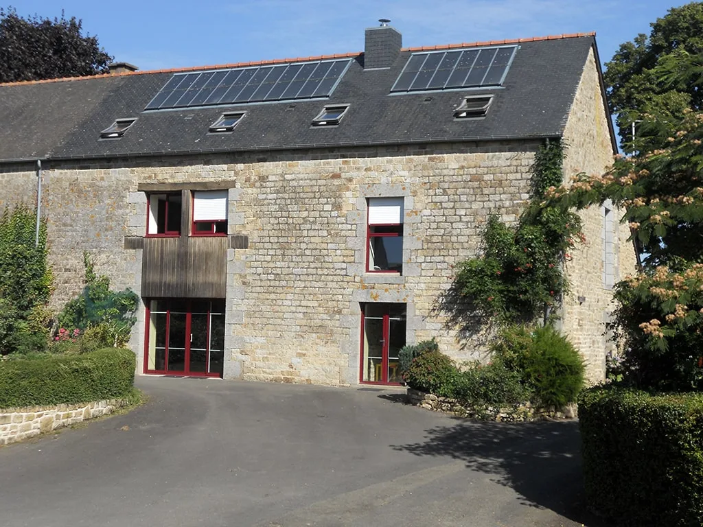Gîte de groupe Gîte le Bas Mena à Rimou — Longère en pierre typique avec cour d'entrée et grand terrain arboré, capacité 19 personnes
