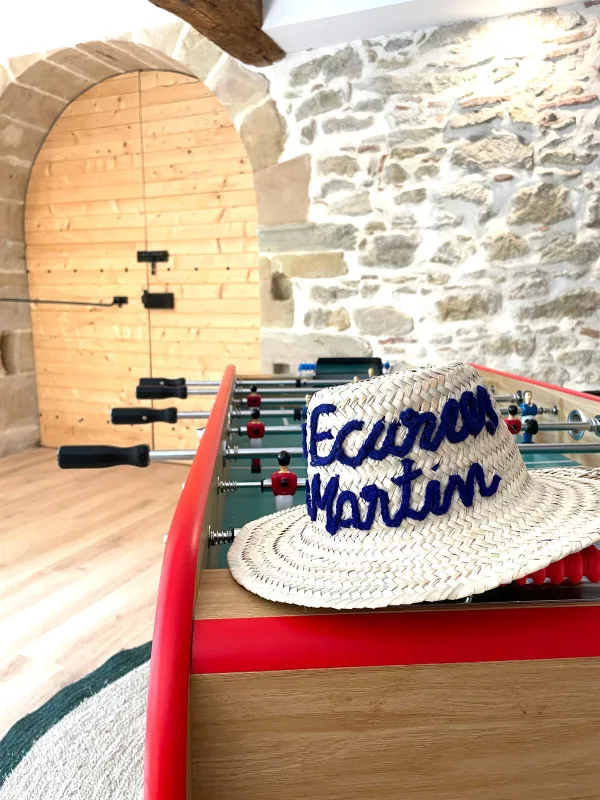Salle de jeux avec baby-foot sous une voûte en pierre typique