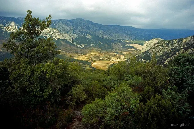 Vue panoramique sur vallée entre falaises de garrigue sous ciel d'orage