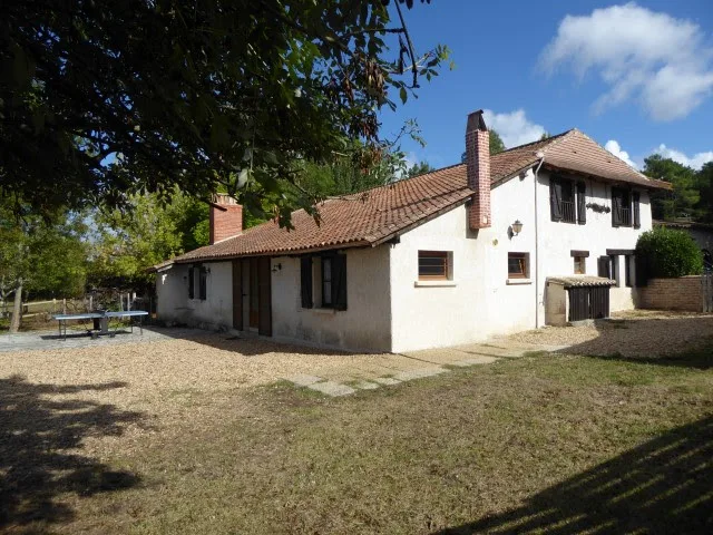 Gîte de groupe Chez Marot à Échourgnac — Façade ensoleillée de la maison périgourdine avec volets bleus et jardin arboré, capacité 23 personnes