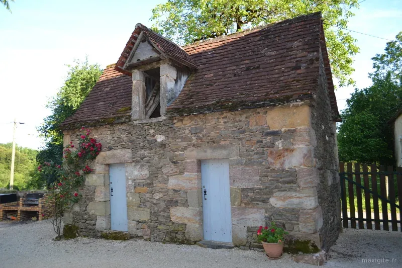 Ancien poulailler en pierre du Quercy avec toiture en tuiles et rosier grimpant