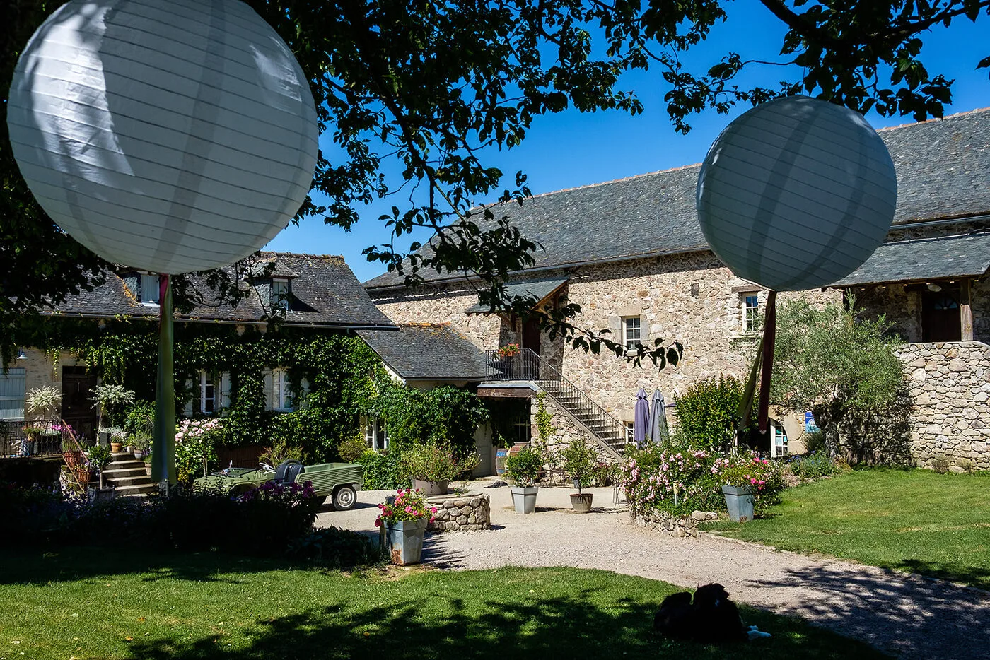 Façade en pierre du domaine décorée de guirlandes pour une réception