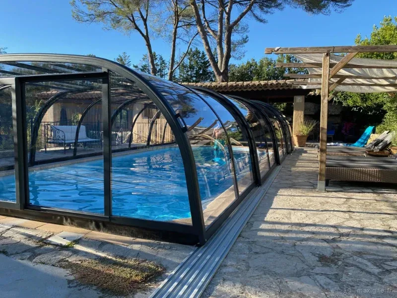 Terrasse ombragée avec vue sur la piscine et le jardin planté d'oliviers