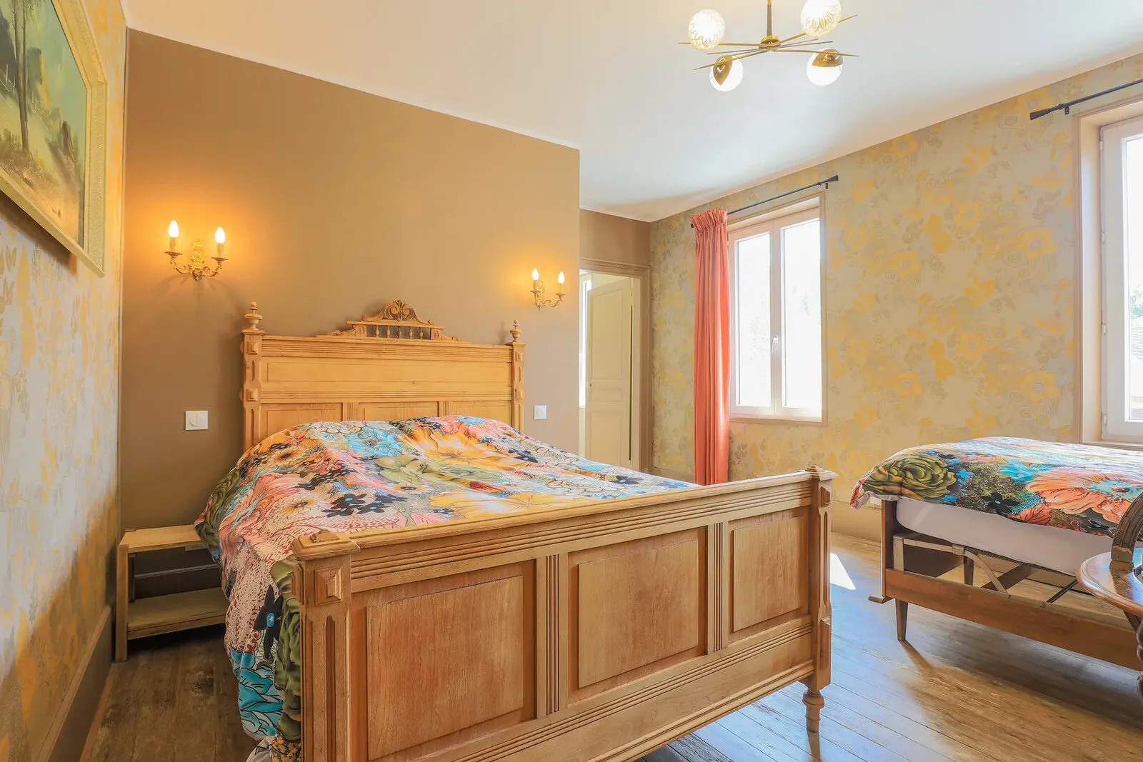 Chambre à l'ancienne avec lit en bois sculpté et linge de lit fleuri
