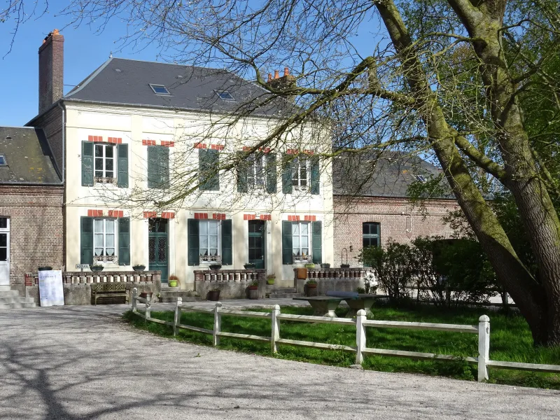 Façade en briques du gîte avec ses fenêtres à arcades et son grand hall d'entrée